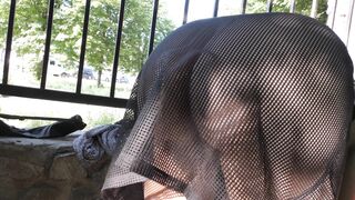 Wife in transparent dress in public park