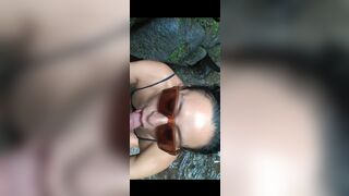 Sexy Latin girl in sunglasses sucking by crowded waterfall